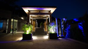 A modern building entrance with a covered staircase, illuminated by ambient lighting and featuring a sign that reads "OceanKock." - Ocean Rock Kalim (Patong)