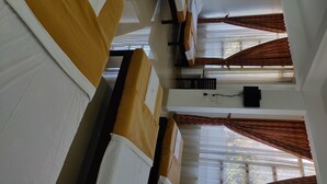 Een hotelkamer met een bed, een bureau, een stoel en een raam met gordijnen.