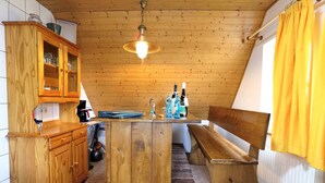 Una cocina con armarios de madera, una isla central y una lámpara colgante.
