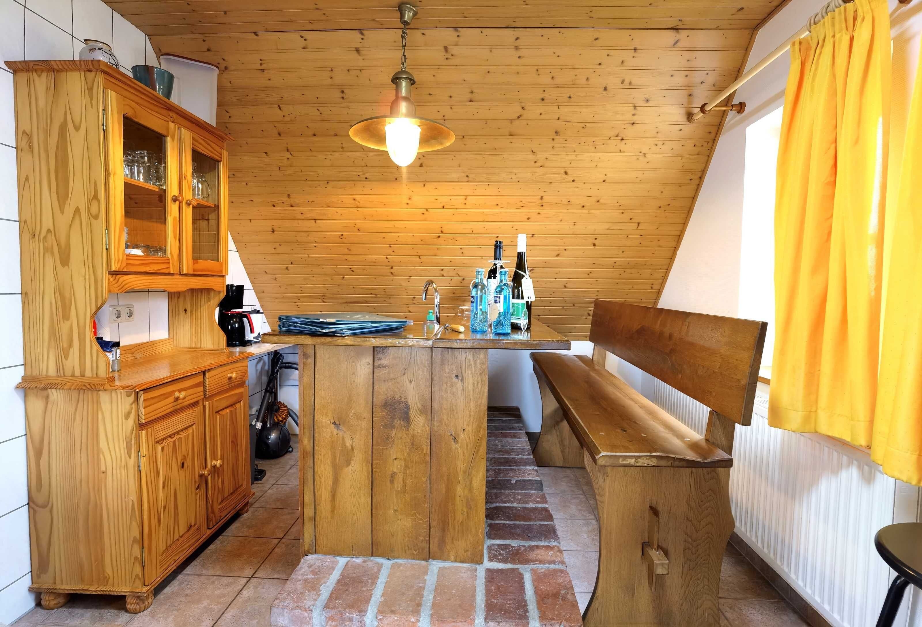 A kitchen with wooden cabinets, a central island, and a hanging light fixture.