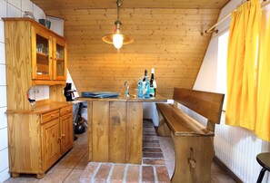 Una cocina con armarios de madera, una isla central y una lámpara colgante.