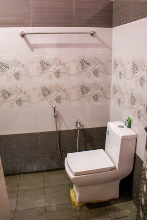 Ein Badezimmer mit Toilette, Dusche und Handtuchhalter.