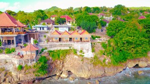 Una località balneare sulla costa, con diversi edifici, alcuni con tetti rossi, arroccata su una scogliera che domina un fiume.