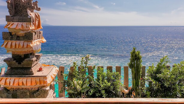 Vista sulla costa con una costruzione in pietra e una recinzione in legno.