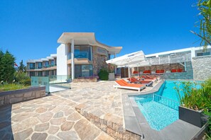 Una piscina al aire libre, tumbonas