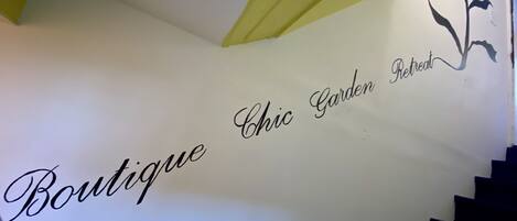 Una escalera con una pared que muestra la inscripción 'Boutique Chic Garden Retreat'.
