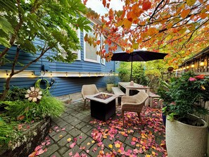 A patio with outdoor furniture, a fire pit, and a potted plant.