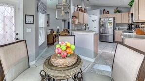A modern kitchen with a central island, stainless steel appliances, and a dining area with a table and chairs.