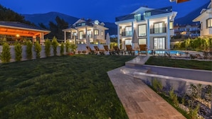 Un moderno complejo residencial con varias casas, una piscina y un césped bien cuidado.