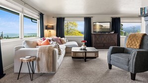 A living room with a sofa, armchair, coffee table, and a TV. - West Nine Stunning Views & Hot Tub (Port Angeles)