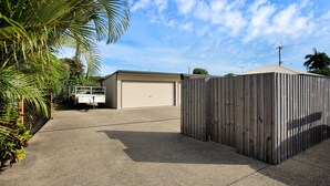 A residential property with a garage, a wooden fence, and a driveway. - North Central Vacation Home (North Mackay)