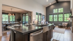 A spacious kitchen with a large island, built-in appliances, and ample natural light from large windows.