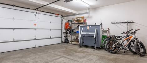 A garage with a white door, a projector, and two bicycles.