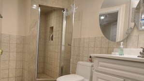 A bathroom with a shower, toilet, and vanity. - Toronto vacation home in North York with free parking (minimum 28 days stay)  (North York)