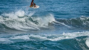 A surfer riding a wave. - Corazon Que Vuela (Cahuita)
