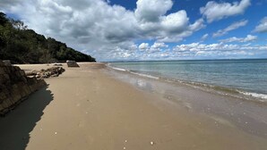 A beach with a stone wall, calm water, and a clear sky. - White Roses a dog friendly retreat for two (Bembridge)