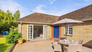 A house with a patio, a blue door, and a table with chairs. - White Roses a dog friendly retreat for two (Bembridge)