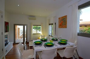 Enjoy meals with family and friends in this dining area, featuring a table for four and a large window offering a view of the outdoors.