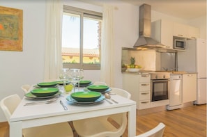 Enjoy meals in this well-equipped kitchen with a dining table, microwave, oven, and dishwasher.