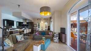 A modern living room with a sofa, coffee table, and TV. - Protaras Villa Rocco Near The Beach (Protaras)