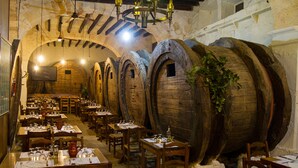 A restaurant with wooden barrels, tables, chairs, and a chandelier. - Private Villa with AC, Wifi, huge pool, garden, sun terraces and BBQ, in Selva (Selva)