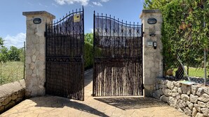 A gated entrance with a stone wall and a metal gate. - Private Villa with AC, Wifi, huge pool, garden, sun terraces and BBQ, in Selva (Selva)