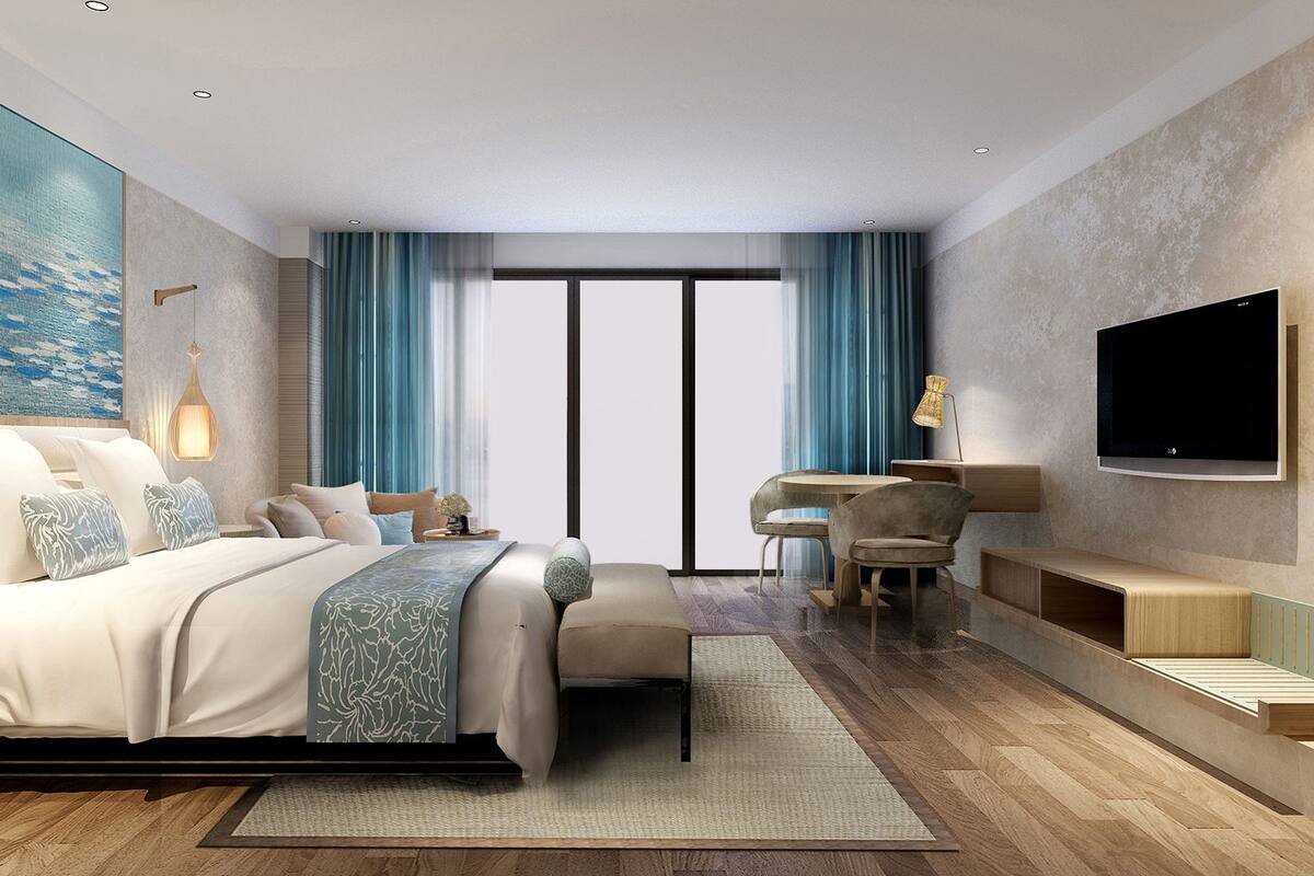 Habitación de hotel moderna con una cama grande, un escritorio, un televisor y vistas a la ciudad.