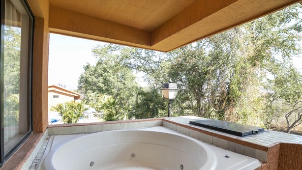 Un jacuzzi con vista a árboles y un edificio al fondo.