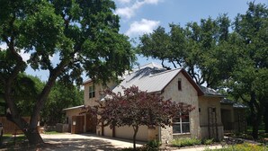 A two-story house with a stone facade, a covered front porch, and a well-maintained lawn. - Fair Oaks Ranch Deer Meadow Estates (Fair Oaks Ranch)