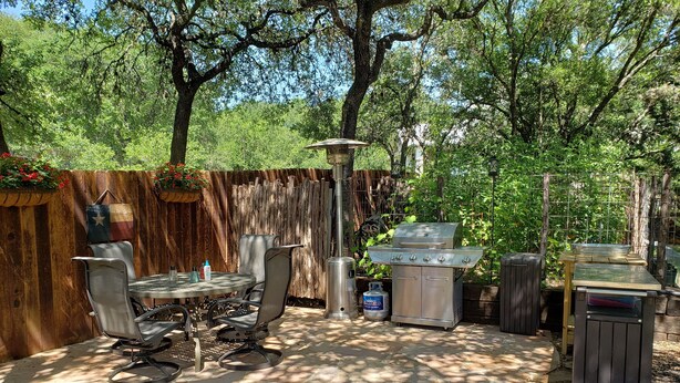 An outdoor patio with a grill, seating area, and a gas tank. - Fair Oaks Ranch Deer Meadow Estates (Fair Oaks Ranch)