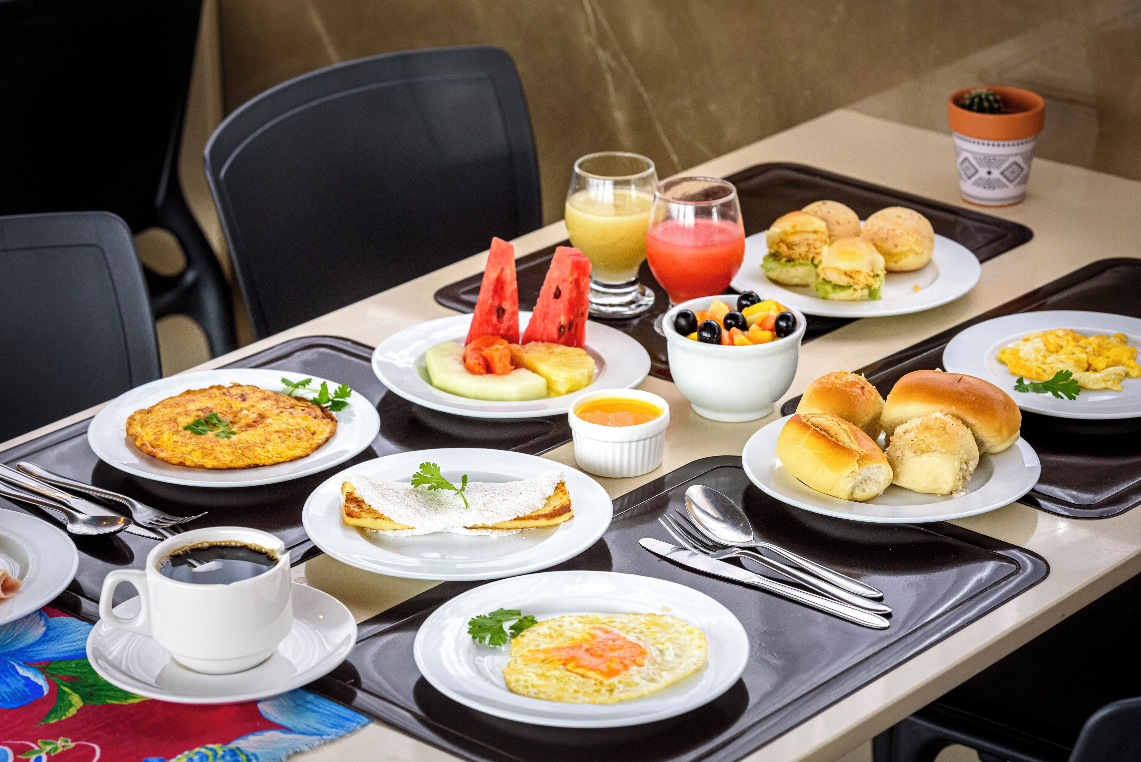 Ein reichhaltiges Frühstücksbuffet mit verschiedenen Speisen, darunter Eier, Gebäck und Obst.