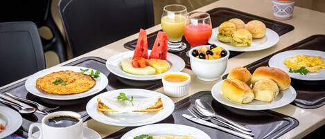 Ein reichhaltiges Frühstücksbuffet mit verschiedenen Speisen, darunter Eier, Gebäck und Obst.