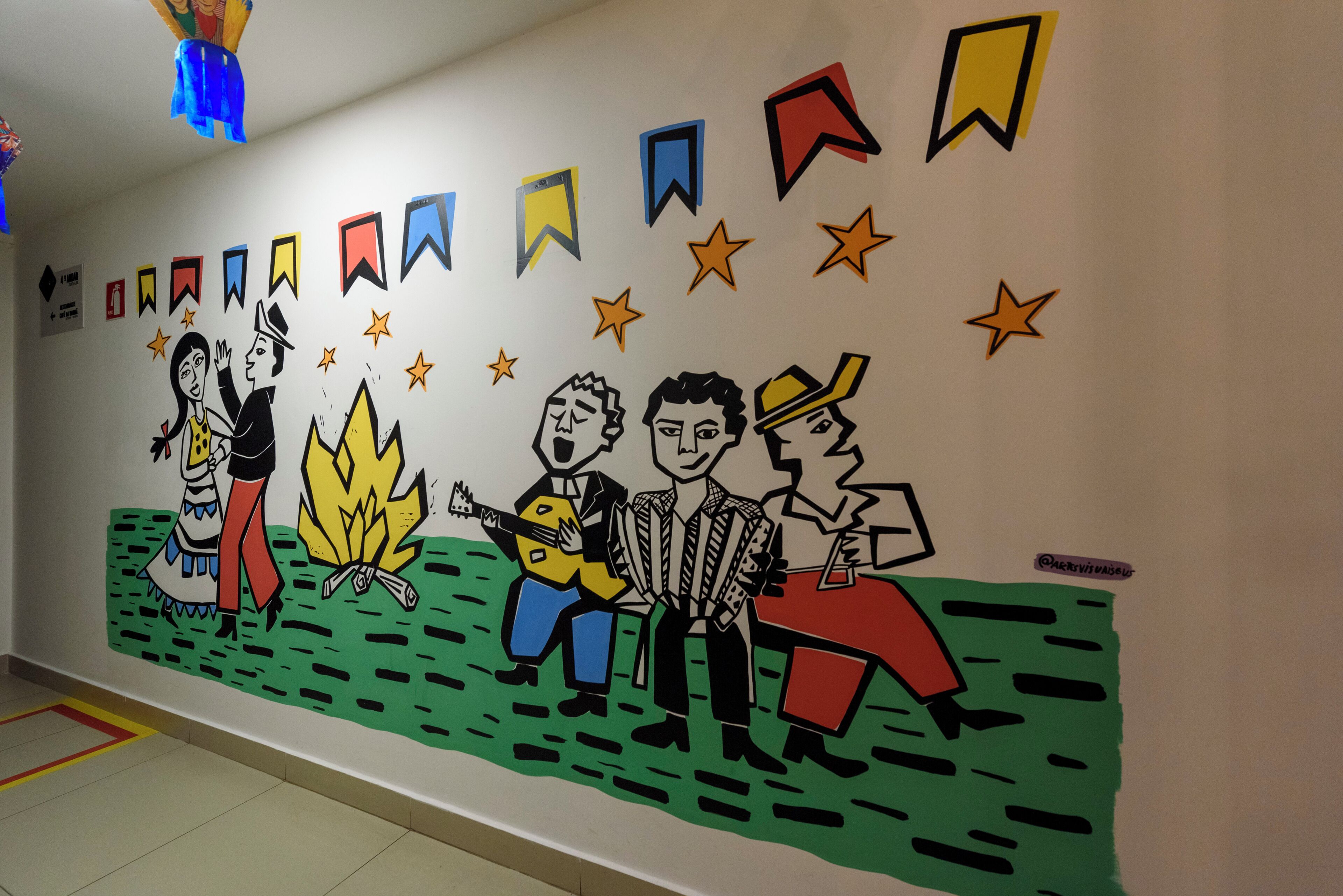 A wall with a mural depicting people and stars.