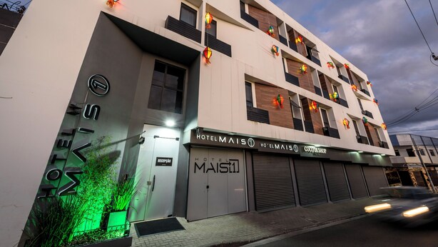 Un hotel con fachada moderna, varios balcones y acceso a nivel de calle.