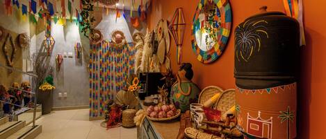A room with a tiled floor, a coffee machine, a wicker basket, and a large ceramic pot.