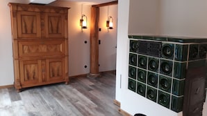 Un couloir avec des meubles de rangement en bois, un appareil électroménager vert et deux lampes fixées au mur.