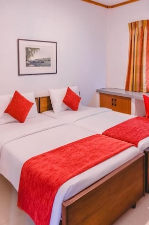 A hotel room with two beds, a wooden headboard, a small desk, and a framed picture on the wall. - Pinnawala Backpack Residencies (Rambukkana)