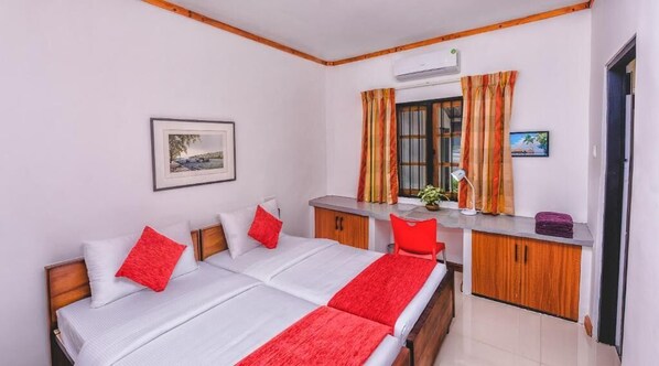 A hotel room with a bed, a desk, a chair, and a window with curtains. - Pinnawala Backpack Residencies (Rambukkana)