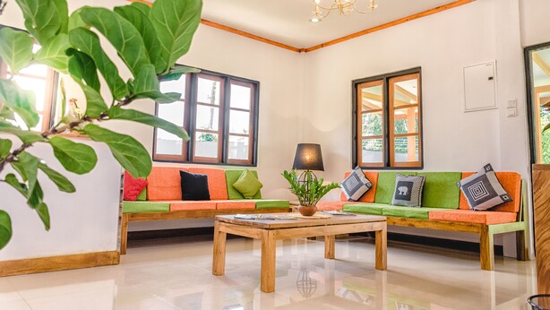 A modern living room with two sofas, a coffee table, and large windows. - Pinnawala Backpack Residencies (Rambukkana)