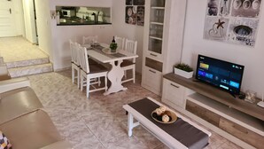 A modern living room with a dining area, a TV, and a staircase leading to another room. - Duplex Parque Santiago 2 close to pool, sea + beach, central, Wifi, heated pool (Costa Adeje)