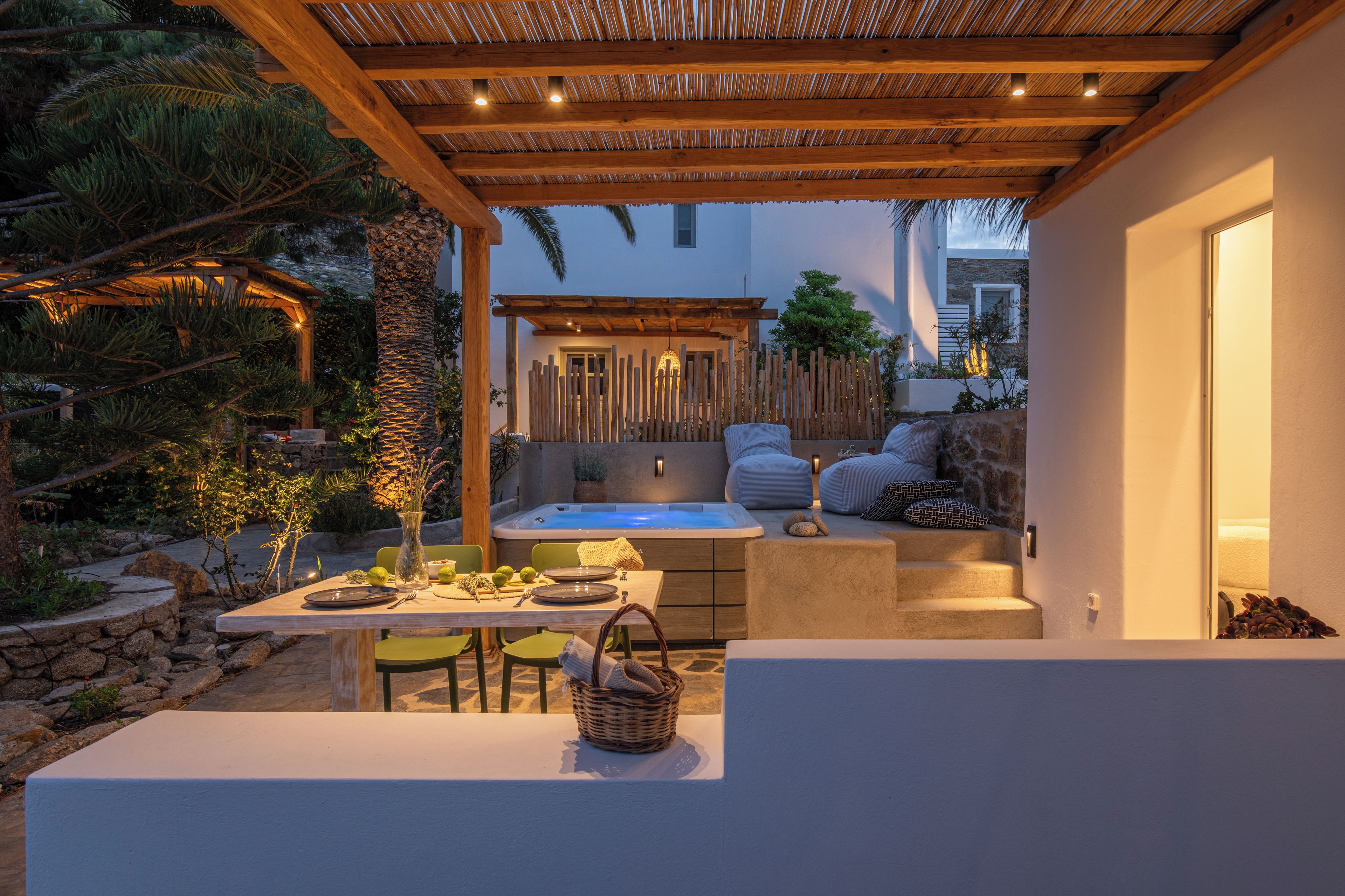 A cozy outdoor seating area with a table, chairs, and a hot tub.