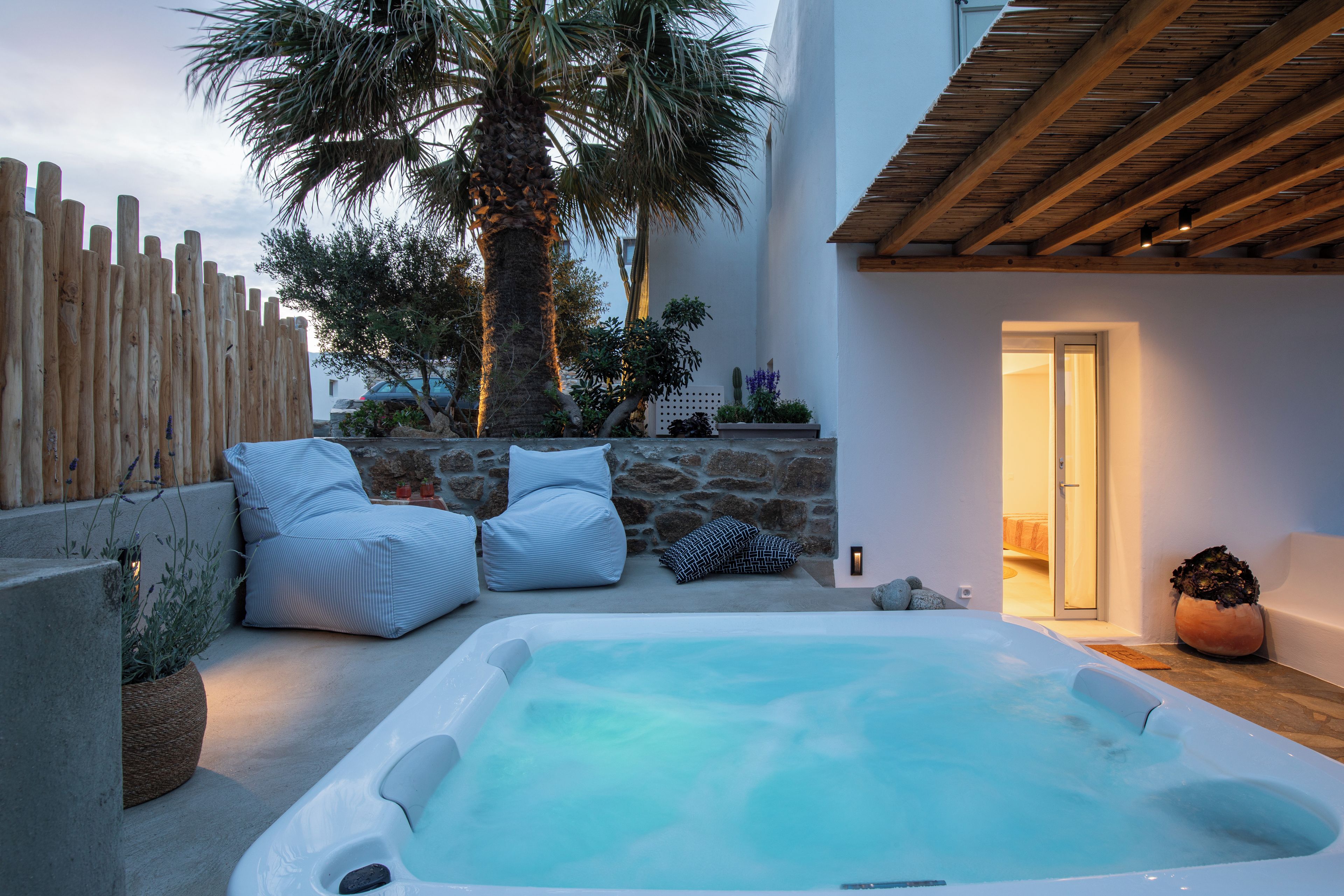 Un bain à remous avec un mur en pierre et une terrasse en bois.