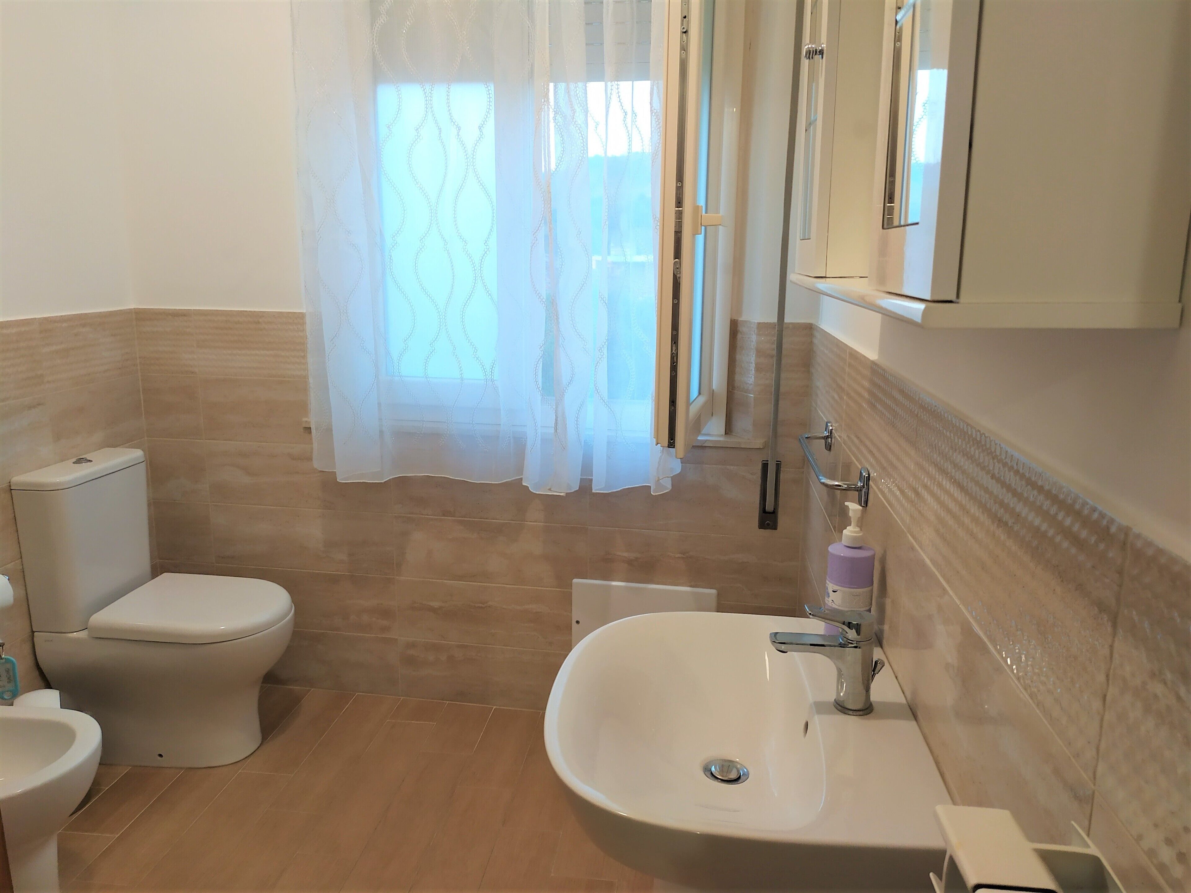A bathroom with a toilet, sink, and shower area.
