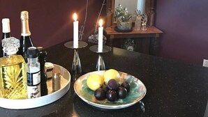 A dining table with a plate of fruit, candles, and bottles of alcohol. - Private room in a shared, centrally located apartment (St. Hanshaugen)