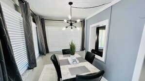 A dining area with a table, chairs, a potted plant, and a ceiling fan. - #7 Heated Pool, Private Patio & Grill (Fort Lauderdale)