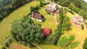 Vista aèria d'una zona rural amb diverses cases envoltades de vegetació.