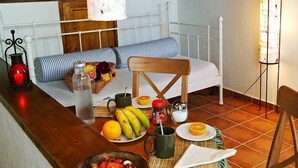 Un desayuno acogedor con una cama, una mesa de madera y diferentes productos para el desayuno.