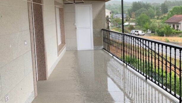 A covered balcony with a view of a residential area. - Upper floor housing (Verín)