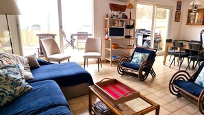 A living room with a sofa, chairs, a coffee table, and a TV.
