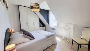 A bedroom with a bed, a hanging light fixture, a chair, and a wardrobe. - L'Olivier by Interhome (Erdeven)